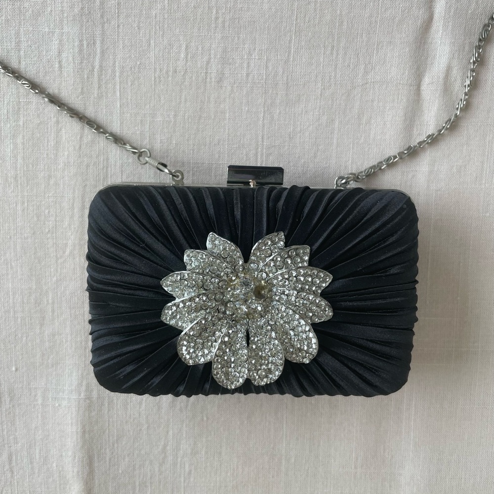 Black box clutch with satin rouching on front accented with rhinestone flower